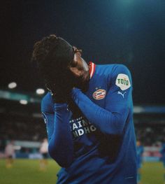 a soccer player wiping his face on the field