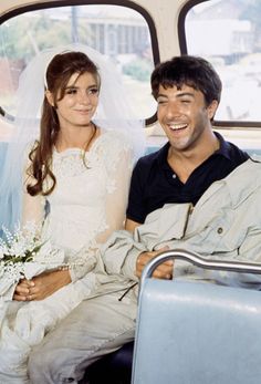 a bride and groom sitting on a bus