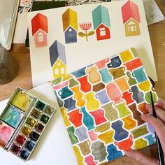 someone is painting houses with watercolors on paper