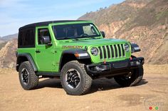 a green jeep is parked in the dirt