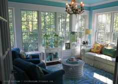 a living room with couches, chairs and a chandelier hanging from the ceiling