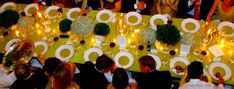 a group of people sitting around a table with plates and silverware on top of it