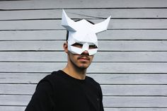 a man wearing a paper mask with horns on his head