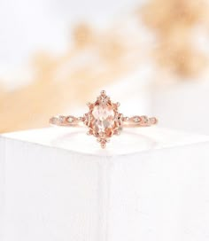 an engagement ring is shown on top of a white box with a blurry background