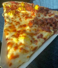 two slices of pizza sitting on top of a white plate in someone's lap