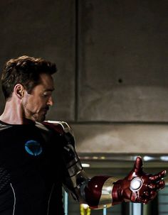 the iron man is holding his hand out in front of him, while looking at something