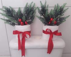 two christmas decorations sitting on top of a toilet