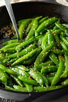 a skillet filled with green beans and sesame seeds