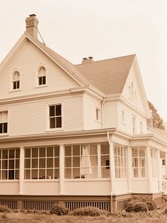 an old photo of a large white house with two stories on the front and second story