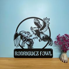 a wooden table topped with a vase filled with flowers and a sign that says rodriquez fowl