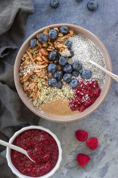 a bowl filled with granola, blueberries, raspberries and almonds