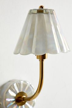 a wall light with a glass shade on it's side and a white background