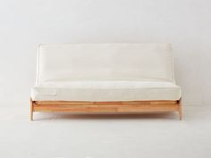 a white couch sitting on top of a wooden frame