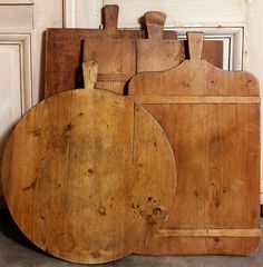 two wooden cutting boards sitting next to each other on top of a counter in front of a door