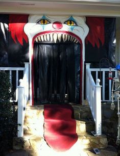 an entrance to a house decorated for halloween with a scary clown's face on the front door