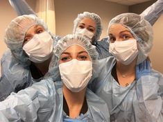 four doctors wearing masks and gowns are posing for the camera