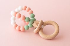 two wooden beads and a ring on a pink background