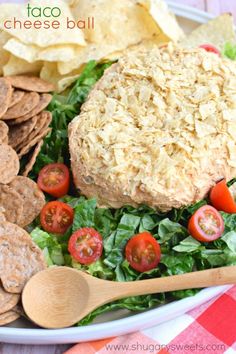 a white plate topped with salad and tortilla cheese ball next to crackers