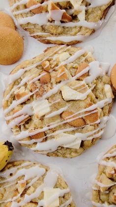 several cookies with icing and bananas on a table