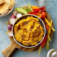 a bowl filled with hummus, carrots and other vegetables