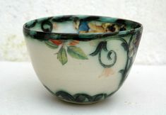 a white and green bowl sitting on top of a table