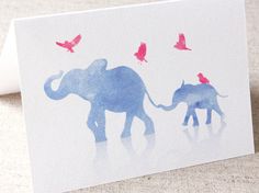 an elephant and its baby are standing in the snow with birds flying above them on a white card