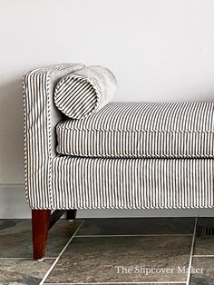 a striped couch sitting on top of a tiled floor