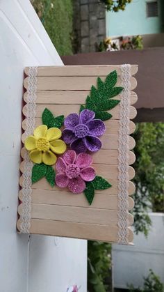 a piece of wood with paper flowers on it