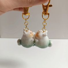 a pair of earrings with two cats on them