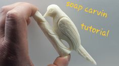 a hand holding a soap carving bird on it's finger with the words soap carving