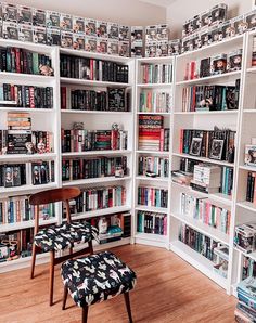 a room filled with lots of books next to a chair and book shelf full of books