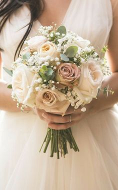 a woman holding a bouquet of flowers in her hands