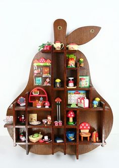 a wooden apple shaped shelf with toys on it's sides and shelves in the shape of an apple