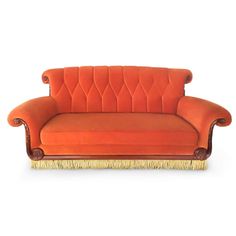 an orange couch sitting on top of a white floor