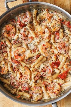 a pan filled with pasta and sauce on top of a wooden table