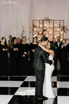 a bride and groom share their first dance at their wedding reception in front of an audience