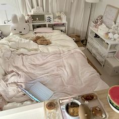 a bed room with a neatly made bed next to a laptop and watermelon