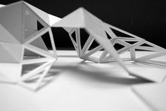 three white origami structures sitting on top of a table