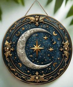 a blue and gold plate with a star and moon in the center, hanging from a rope