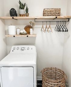 a white washer and dryer in a small room with shelves above the washer