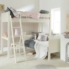 a white bunk bed sitting next to a fireplace