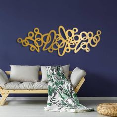 a couch sitting in front of a blue wall with gold metal art on the wall