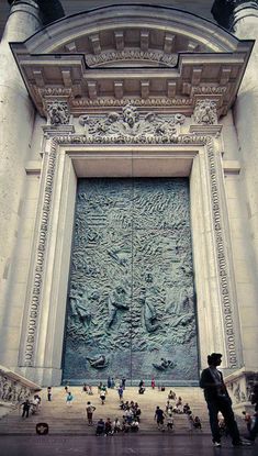 people are standing in front of the entrance to an ornate building with carvings on it