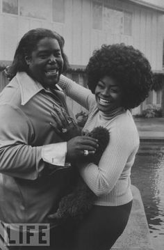 an old black and white photo of two people hugging in front of a swimming pool