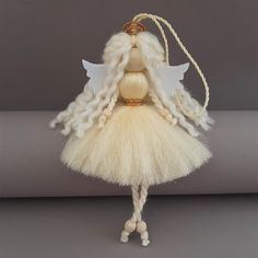 an angel doll with blonde hair and white wings