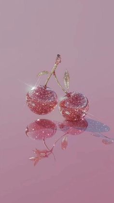 two pieces of pink glass sitting on top of a reflective surface next to each other