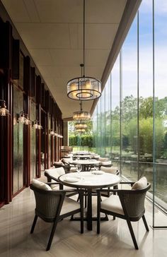 a dining room with tables and chairs next to large windows