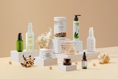 several different types of skin care products displayed on white pedestals against a beige background