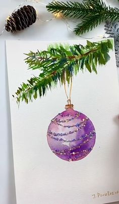 an ornament hanging from a christmas tree branch with pine cones and glitters