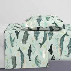 two sheets with dolphins on them are next to each other in front of a white wall